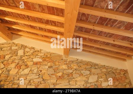 Stonewall et plafond en planches de bois dans la maison de chalet dans les montagnes. intérieur d'une chambre d'hôtel Banque D'Images