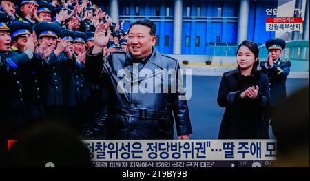 Les informations télévisées de la gare de Yongsan à Séoul montrent le dirigeant nord-coréen Kim Jong un (C) et sa fille (2e R), qui s'appellerait Kim Ju AE, faire des vagues alors qu'il rejoint une séance photo avec un groupe d'ingénieurs et de scientifiques, qui ont contribué au lancement réussi d'un satellite de reconnaissance par le pays, à l'Administration nationale de la technologie aérospatiale à Pyongyang. Le dirigeant nord-coréen Kim Jong-un a salué le lancement réussi par le pays d'un satellite de reconnaissance comme un événement révélateur du déploiement d'une « garde spatiale » surveillant les activités militaires ennemies, ont rapporté les médias d'État sur Novem Banque D'Images