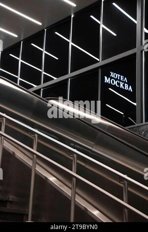 Belgrade, Serbie- 20 novembre 2023 : escalier de métro escalator avec réflexion des lumières et panneau de l'hôtel Moscou en caractères cyrilliques dans la nuit, détail Banque D'Images