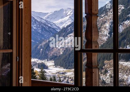 Vue pittoresque depuis le balcon d'une maison en bois sur les sommets enneigés des montagnes alpines, concept de vacances respectueux de l'environnement Banque D'Images