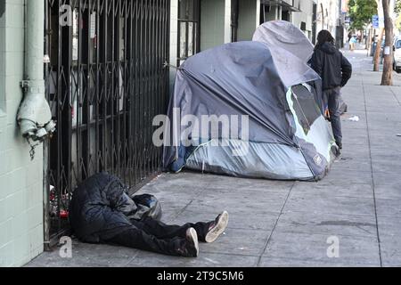 San Francisco, CA, USA - 26 juillet 2023 : un homme sans abri dort dans la rue dans le centre-ville de San Francisco. Banque D'Images