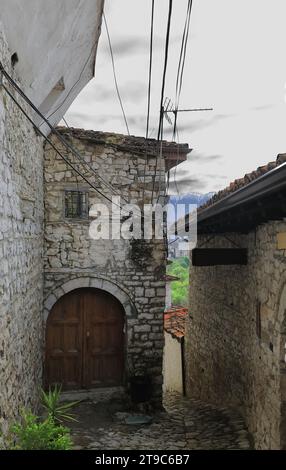 063 ruelle étroite dans le quartier historique de Mangalem, à l'époque ottomane, avec des sols pavés, des murs en maçonnerie de pierre. Berat-Albanie. Banque D'Images