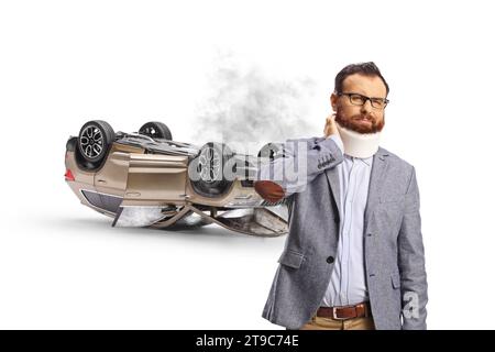 Homme barbu avec un collier cervical devant une voiture cassée isolé sur fond blanc Banque D'Images