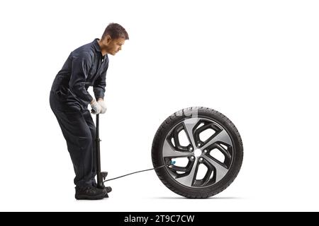 Mécanicien automobile utilisant une pompe manuelle pour un pneu isolé sur fond blanc Banque D'Images