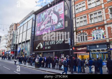 Londres, Royaume-Uni. 24 novembre 2023. Les fans font la queue devant HMV sur Oxford Street avant sa réouverture. Le groupe de ska-pop britannique Madness a ouvert la boutique et signé des copies de leur dernier album ''Theatre of the Absurd Presents c'est la vie''. Le magasin de divertissement emblématique revient à son emplacement phare au 363 Oxford Street après quatre ans. Crédit : Vuk Valcic/Alamy Live News Banque D'Images