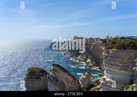 Une journée ensoleillée à Bonifacio, en Corse, la ville perchée sur une falaise. La mer bleue fusionne parfaitement avec le ciel azur, créant une vue imprenable sur la côte. Banque D'Images