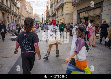 Barcelone, Barcelone, Espagne. 24 novembre 2023. Un groupe de militants capitalistes se produit et donne des vêtements dans le centre de Barcelone en plein Vendredi fou. L’action est une protestation contre les grandes marques commerciales de mode rapide telles que Zara, Shein et H&M, qui produisent deux fois plus de vêtements qu’il y a vingt ans grâce à des processus qui contaminent et exploitent les gens. (Image de crédit : © Marc Asensio Clupes/ZUMA Press Wire) USAGE ÉDITORIAL SEULEMENT! Non destiné à UN USAGE commercial ! Banque D'Images