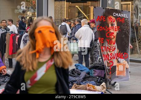 Barcelone, Barcelone, Espagne. 24 novembre 2023. Un groupe de militants capitalistes se produit et donne des vêtements dans le centre de Barcelone en plein Vendredi fou. L’action est une protestation contre les grandes marques commerciales de mode rapide telles que Zara, Shein et H&M, qui produisent deux fois plus de vêtements qu’il y a vingt ans grâce à des processus qui contaminent et exploitent les gens. (Image de crédit : © Marc Asensio Clupes/ZUMA Press Wire) USAGE ÉDITORIAL SEULEMENT! Non destiné à UN USAGE commercial ! Banque D'Images