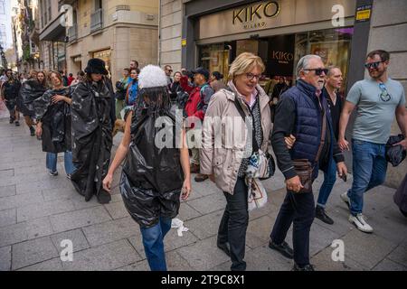 Barcelone, Barcelone, Espagne. 24 novembre 2023. Un groupe de militants capitalistes se produit et donne des vêtements dans le centre de Barcelone en plein Vendredi fou. L’action est une protestation contre les grandes marques commerciales de mode rapide telles que Zara, Shein et H&M, qui produisent deux fois plus de vêtements qu’il y a vingt ans grâce à des processus qui contaminent et exploitent les gens. (Image de crédit : © Marc Asensio Clupes/ZUMA Press Wire) USAGE ÉDITORIAL SEULEMENT! Non destiné à UN USAGE commercial ! Banque D'Images