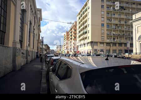 Genova, Italie - novembre 2023 - rue avec des voitures garées par son bord vu du trottoir Banque D'Images