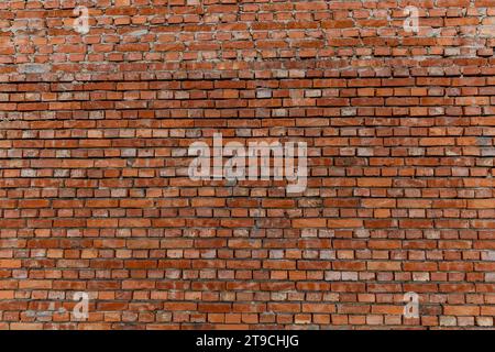 Bâtiment en briques rouges prévu pour la démolition, mur mal placé par le maçon, briques empilées de travers Banque D'Images