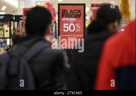 New York, États-Unis. 24 novembre 2023. Les gens passent devant les panneaux de réduction du Black Friday annoncés au magasin Macy's à l'intérieur du Queens Center Mall, New York, NY, le 24 novembre 2023. Malgré les rabais traditionnels et les bas prix offerts le Black Friday, la première journée de shopping des fêtes qui commence après Thanksgiving, les détaillants craignent l'inflation et l'endettement croissant des cartes de crédit gâchera les revenus des fêtes. (Photo Anthony Behar/Sipa USA) crédit : SIPA USA/Alamy Live News Banque D'Images