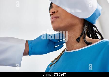 malade jolie femme afro-américaine fermant les yeux pendant que son médecin indien examine ses ganglions lymphatiques Banque D'Images