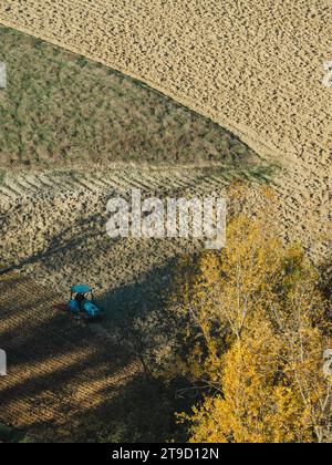Tracteur rampé labourer le sol aride sec sur la colline de la vallée d'Arda, en Italie, pour semer le blé pendant la saison d'automne en novembre Banque D'Images