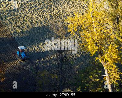 Tracteur rampé labourer le sol aride sec sur la colline de la vallée d'Arda, en Italie, pour semer le blé pendant la saison d'automne en novembre Banque D'Images
