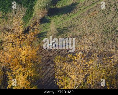 Tracteur rampé labourer le sol aride sec sur la colline de la vallée d'Arda, en Italie, pour semer le blé pendant la saison d'automne en novembre Banque D'Images