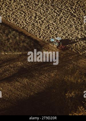 Tracteur rampé labourer le sol aride sec sur la colline de la vallée d'Arda, en Italie, pour semer le blé pendant la saison d'automne en novembre Banque D'Images