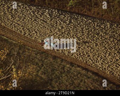 Tracteur rampé labourer le sol aride sec sur la colline de la vallée d'Arda, en Italie, pour semer le blé pendant la saison d'automne en novembre Banque D'Images