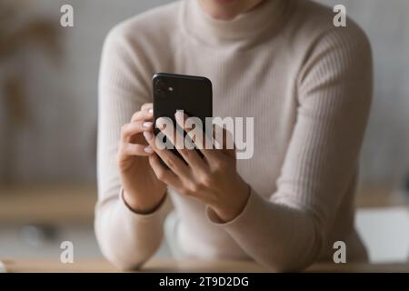 Gros plan recadré femme à l'aide d'un smartphone moderne à l'intérieur Banque D'Images