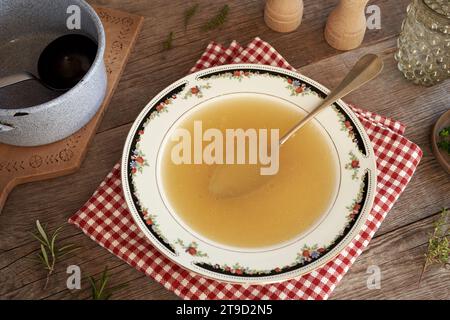 Bouillon d'os de poulet dans un bol à soupe avec une cuillère Banque D'Images