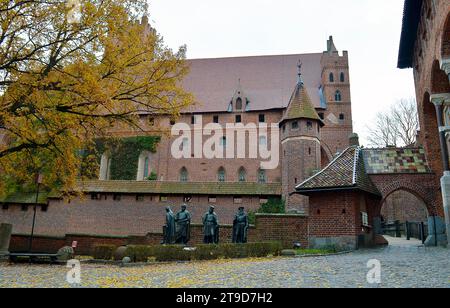 MALBORK, POLOGNE - 6 NOVEMBRE 2023 : le plus grand château du monde avec des statues de grands maîtres de l'ordre Teutonique, Banque D'Images