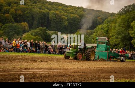 Les spectateurs se rassemblent pour assister au concours de traction des tracteurs d'époque : le charme rustique rencontre la force dans les prairies Banque D'Images