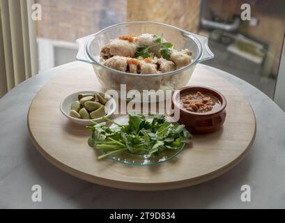 Délicieux poulet à la vapeur au riz (riz au poulet du Hainanais) servir avec de l'ail mariné, du concombre et de la sauce sucrée au Chili sur un plateau rond en bois Aliments halal, Banque D'Images