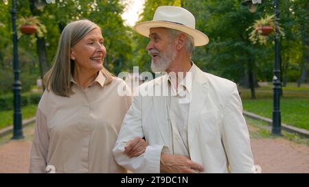 Close up famille heureuse caucasien romantique senior couple femme mari homme femme marchant à l'extérieur du parc de la ville parler discuter sourire rire week-end Banque D'Images