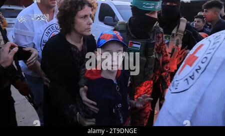 Khan Younis, territoire palestinien occupé. 24 novembre 2023. Des membres de la Croix-Rouge reçoivent des prisonniers israéliens et étrangers des membres de la branche militaire du Hamas Al-Qassam le vendredi 24 novembre 2023, à Khan Younis, au Sud de la bande de Gaza, dans le cadre de la pause négociée limitée dans les combats entre Israël et le Hamas, la première depuis le début des hostilités le 7 octobre. Israël a également libéré 39 Palestiniens, 24 femmes et 15 enfants, de la prison d’Ofer, dans le cadre d’un accord d’échange. Photo du Hamas Press Service/ crédit : UPI/Alamy Live News Banque D'Images