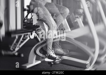 Jambes de femme sur un vélo stationnaire se déplaçant rapidement avec un effet de flou de mouvement Banque D'Images