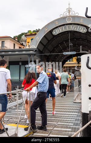Un matelot de pont aide les passagers à débarquer d'un ferry Navigazione Laghi au terminal de Bellagio, Lombardie, Italie. Banque D'Images