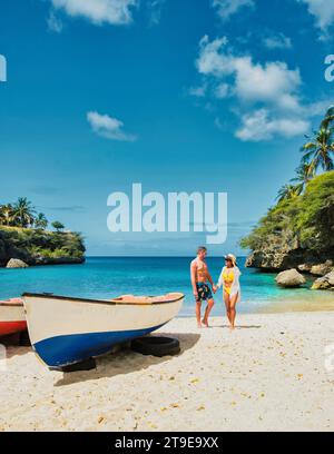 Un couple d'hommes et de femmes en short de bain et bikinis à Playa Lagun Beach Curaçao, un couple en vacances d'été à Curaçao Banque D'Images