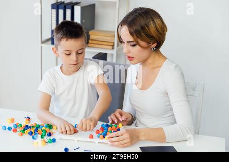 Professeur jouant à des jeux éducatifs avec le garçon à l'école Banque D'Images