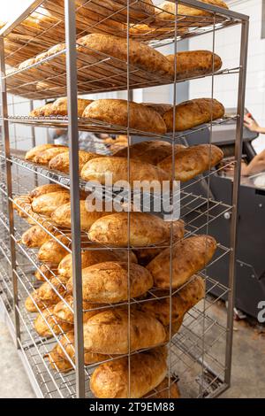 Pain frais à l'intérieur d'une boulangerie prêt à vendre. Production alimentaire industrielle Banque D'Images