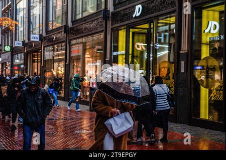 Amsterdam, pays-Bas. 24 novembre 2023. Une personne vue avec un parapluie pendant une forte tempête. À Amsterdam, les magasins sont prêts avec des offres Black Friday, et les vitrines des magasins sont décorées avec des bannières de vente pour attirer les gens pendant le Black Friday. Les plus jeunes, en particulier, attendent le jour de réduction après Thanksgiving de l'Amérique pour acheter des choses. (Photo Ana Fernandez/SOPA Images/Sipa USA) crédit : SIPA USA/Alamy Live News Banque D'Images