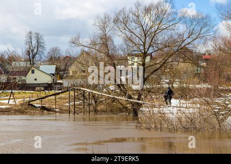 Pont piétonnier suspendu dans la campagne pendant l'inondation printanière Banque D'Images