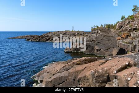 Île Valaam, eau claire du lac, rivage rocheux et pins qui poussent dessus Banque D'Images