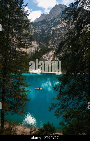 Vue imprenable sur le lac de Braies avec le bateau en bois typique encadré par des arbres. Beau lac bleu vif Pragser Wildsee dans la nature de Fanes-Senes-Braies Banque D'Images