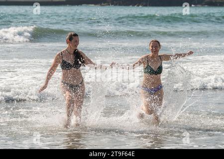 Deux femmes vêtues de bikini s'amusent dans la mer à Warren Beach, Rosscarbery, West Cork, Irlande. Banque D'Images