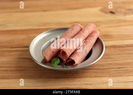 Tranches de saucisse de bœuf fumé, saucisse finement tranchée sur la table en bois Banque D'Images