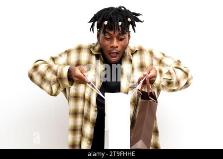 Photo d'un jeune africain noir choqué sur des dreadlocks avec des sacs à provisions isolés sur fond blanc. Solde du Vendredi fou Banque D'Images