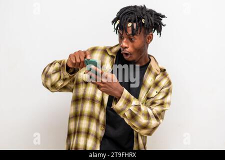 portrait de jeune homme noir joyeux envoyant un message sur un téléphone portable. Heureux homme afro-américain utilisant smartphone, appréciant le chat en ligne, messagerie Banque D'Images