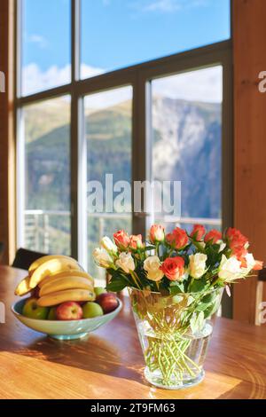 Table à manger avec roses colorées et bol de banane, station de montagne Banque D'Images