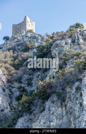 La ruine de la tour Castelmarino se dessine sur une colline rocheuse escarpée à la tourbière sur le rivage, filmée dans une lumière brillante de début d'automne près de Marina di Alberese, Toscane, Italie Banque D'Images