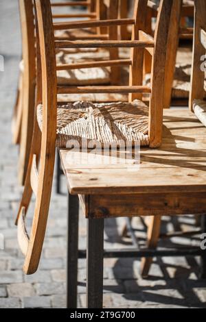 Chaises en bois, inversées, surélevées sur table dans le café de rue. Banque D'Images