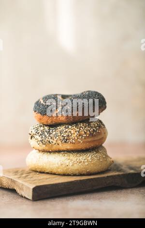 Bagels de grains entiers faits maison avec des graines de sésame et de pavot sur une table Banque D'Images