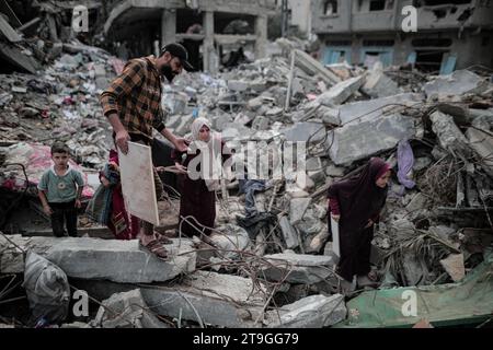 25 novembre 2023 : Deir Al-Balah, bande de Gaza, Palestine. 24 novembre 2023. Les Palestiniens sont assis parmi les décombres de leur maison détruite à Deir Al-Balah, pendant une trêve après 7 semaines de bombardements israéliens incessants. Vendredi 24 novembre, une trêve humanitaire de quatre jours entre Israël et le Hamas a commencé, avec des Gazaouis déplacés qui se sont rendus chez eux et ont évalué les dégâts causés par les frappes israéliennes continues. Pourtant, les Palestiniens déplacés dans le sud de Gaza n’ont pas été autorisés à voyager vers le nord pour évaluer les dommages causés à leurs maisons et à leurs biens (image de crédit : © Adel Al Hwajre/IMAGESLIVE via ZUMA Press Wire) E Banque D'Images