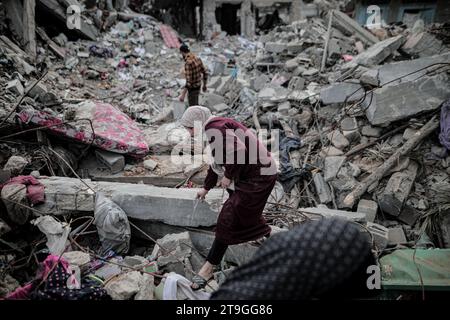 25 novembre 2023 : Deir Al-Balah, bande de Gaza, Palestine. 24 novembre 2023. Les Palestiniens sont assis parmi les décombres de leur maison détruite à Deir Al-Balah, pendant une trêve après 7 semaines de bombardements israéliens incessants. Vendredi 24 novembre, une trêve humanitaire de quatre jours entre Israël et le Hamas a commencé, avec des Gazaouis déplacés qui se sont rendus chez eux et ont évalué les dégâts causés par les frappes israéliennes continues. Pourtant, les Palestiniens déplacés dans le sud de Gaza n’ont pas été autorisés à voyager vers le nord pour évaluer les dommages causés à leurs maisons et à leurs biens (image de crédit : © Adel Al Hwajre/IMAGESLIVE via ZUMA Press Wire) E Banque D'Images