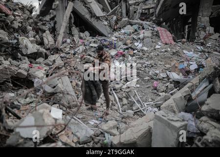 25 novembre 2023 : Deir Al-Balah, bande de Gaza, Palestine. 24 novembre 2023. Les Palestiniens sont assis parmi les décombres de leur maison détruite à Deir Al-Balah, pendant une trêve après 7 semaines de bombardements israéliens incessants. Vendredi 24 novembre, une trêve humanitaire de quatre jours entre Israël et le Hamas a commencé, avec des Gazaouis déplacés qui se sont rendus chez eux et ont évalué les dégâts causés par les frappes israéliennes continues. Pourtant, les Palestiniens déplacés dans le sud de Gaza n’ont pas été autorisés à voyager vers le nord pour évaluer les dommages causés à leurs maisons et à leurs biens (image de crédit : © Adel Al Hwajre/IMAGESLIVE via ZUMA Press Wire) E Banque D'Images