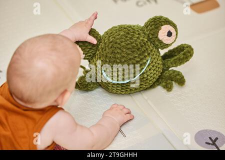 bébé joue avec un jouet tricoté dans la pépinière Banque D'Images